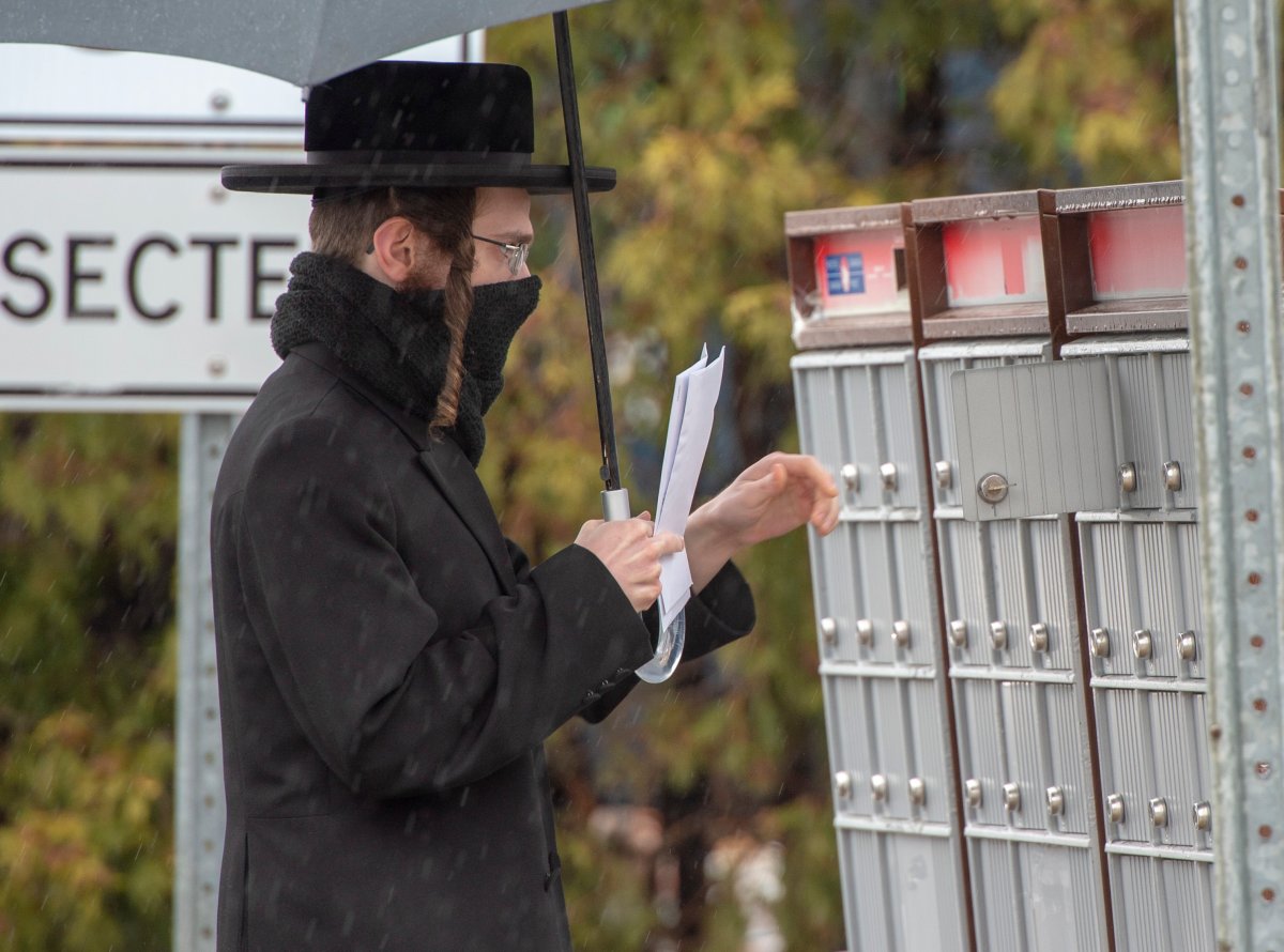 A member of the Tosh de Boisbriand community gets his mail on Monday, March 30, 2020 in Boisbriand, Que.