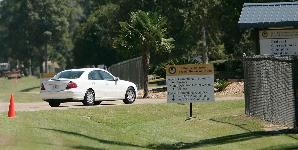 In this Sept. 26, 2006 photo, a person drive through the gates of a federal prison in Oakdale, L.A.