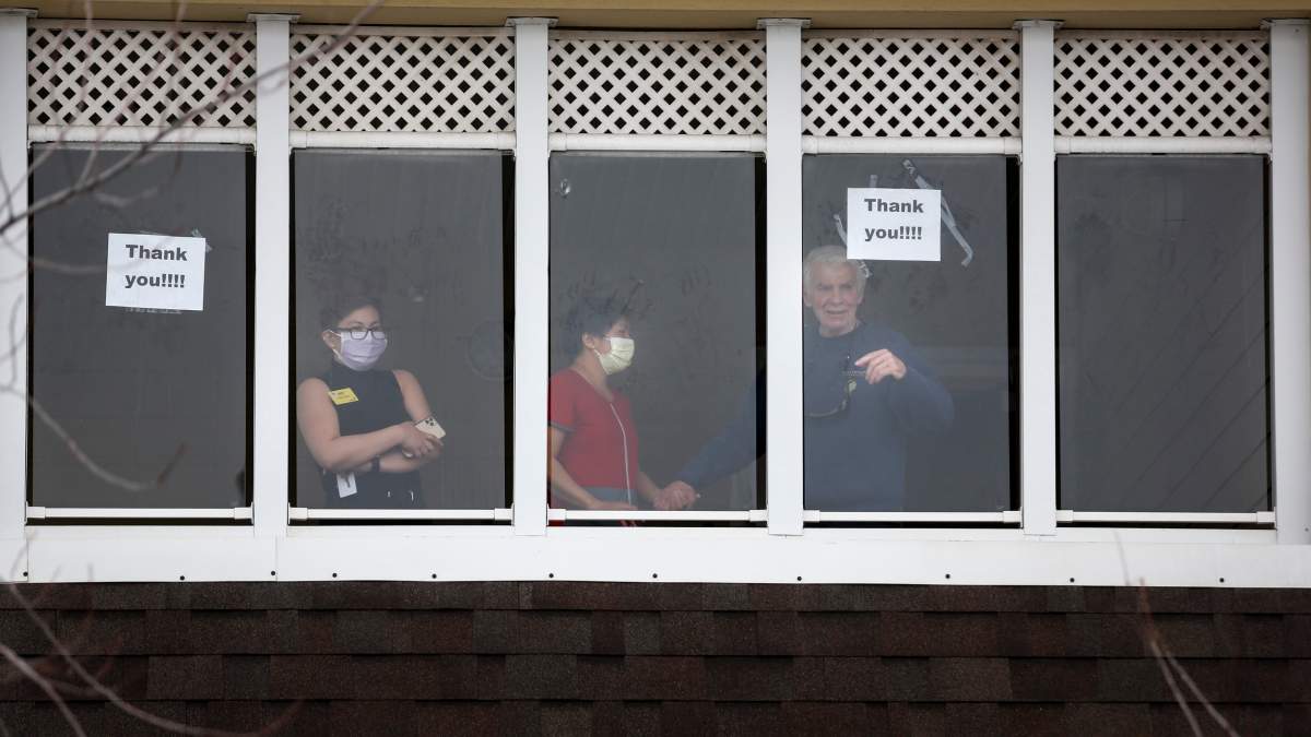 Residents and staff wave to family and friends who came out to show support for those in Calgary's McKenzie Towne Continuing Care Centre amid the COVID-19 crisis on Thursday, April 2, 2020.