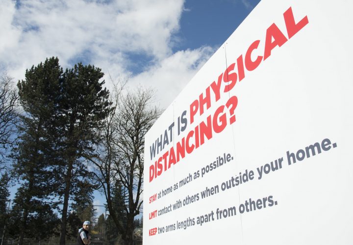 A man walks past a physical distancing sign at the Royal Columbian Hospital in New Westminster, B.C. Friday, April 3, 2020.
