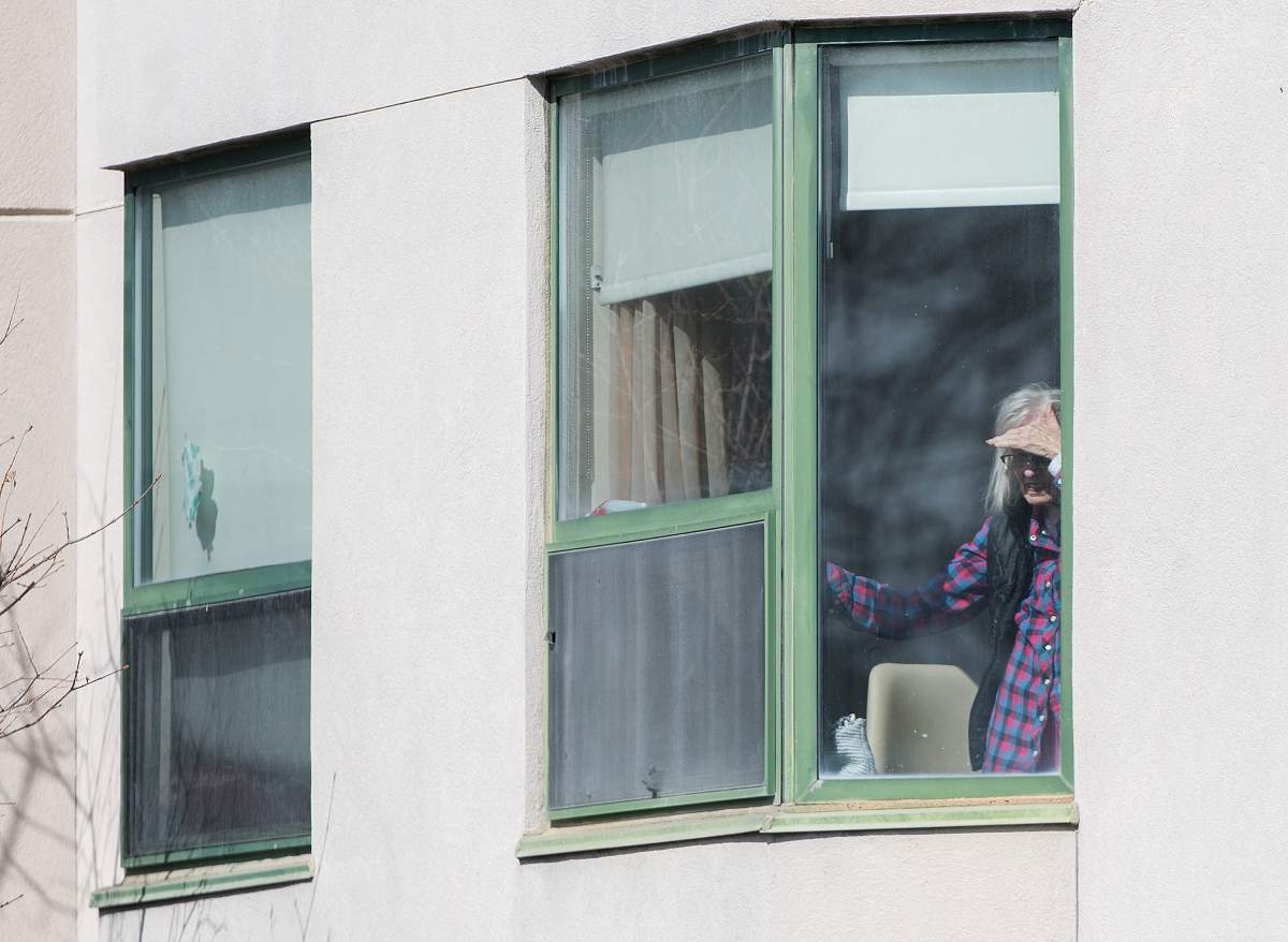 An elderly woman looks out of a window at Maison Herron, a long-term care home in the Montreal suburb of Dorval, Sunday, April 12, 2020, as COVID-19 cases rise in Canada and around the world.