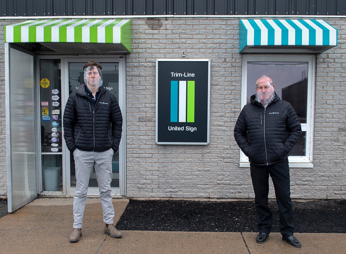 Owner Matt Symes, right, and associate Jonathan Kummer, display face shields for health-care workers at United Signs in Dartmouth, N.S. on Wednesday, April 15, 2020. Symes and his team has been able to source scarce materials, including sheets of polycarbonate, and 24 km of elastic from small-town quilting stores around Nova Scotia to address a need presented by the COVID-19 crisis. 