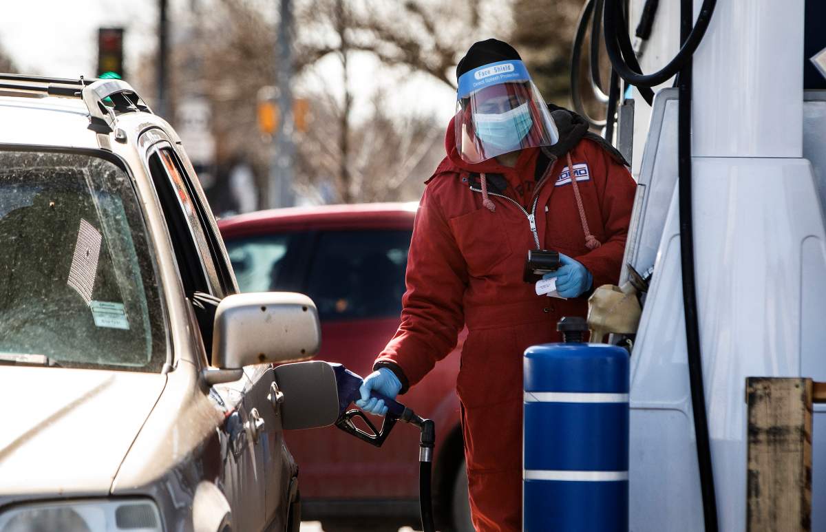 A Domo employee wears full PPE for protection as he fills up cars during the COVID-19 pandemic in Edmonton, Alta., on Saturday, April 18, 2020.