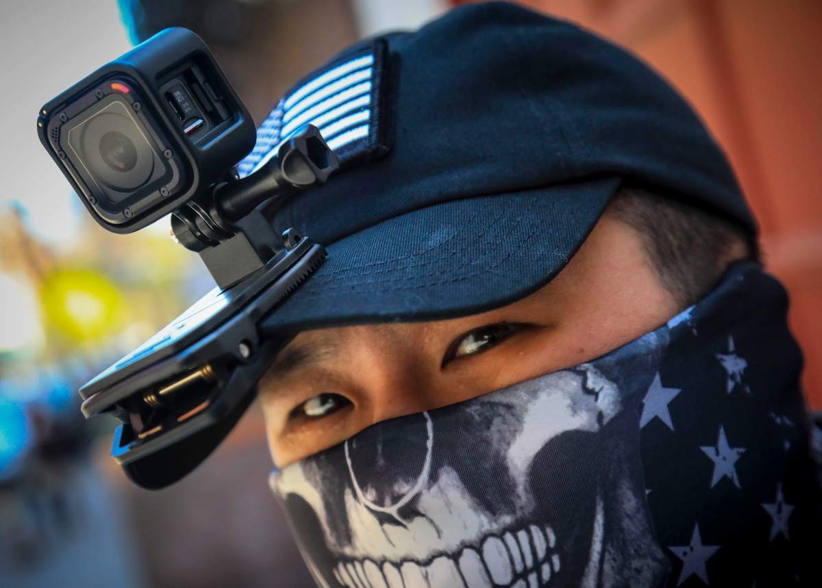 Eddie Song a Korean American entrepreneur, arrives at his motorcycle storage garage wearing a video camera clipped to his cap and a face mask due to COVID-19, Sunday April 19, 2020, in East Village neighborhood of New York. 