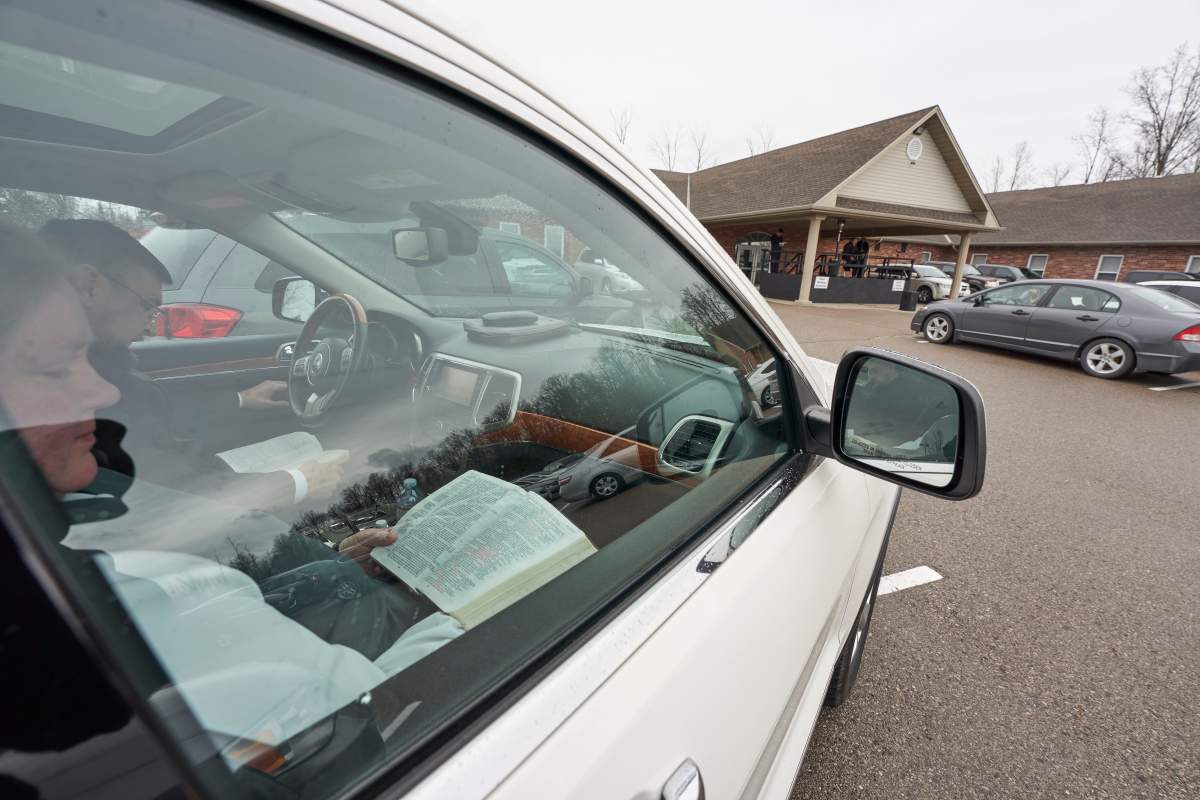 Parishioners read from the Bible in their vehicles in the parking lot at the Church of God in Aylmer, Ont., on Sunday, April 26, 2020.