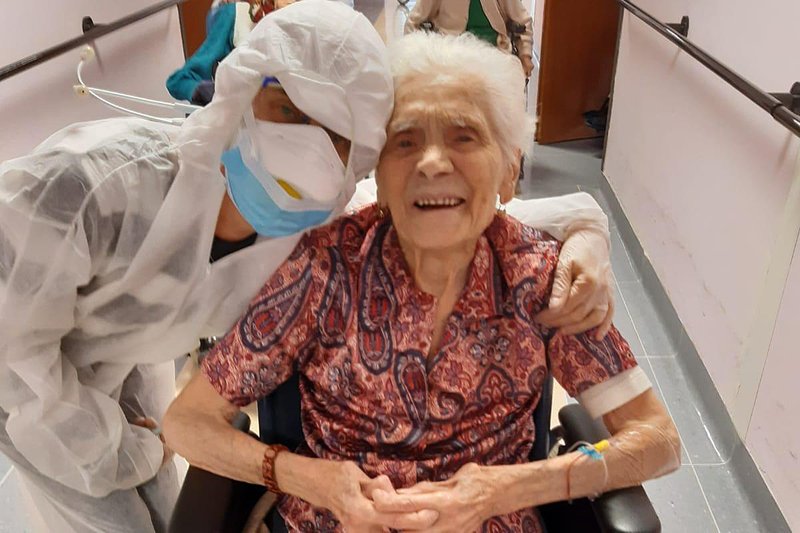 In this photo taken on April 1, 2020, 103-year-old Ada Zanusso, poses with a nurse at the old people's home "Maria Grazia" in Lessona, northern Italy, after recovering from Covid-19 infection. To recover from coronavirus infection, as she did, Zanusso recommends courage and faith, the same qualities that have served her well in her nearly 104 years on Earth. The new coronavirus causes mild or moderate symptoms for most people, but for some, especially older adults and people with existing health problems, it can cause more severe illness or death.