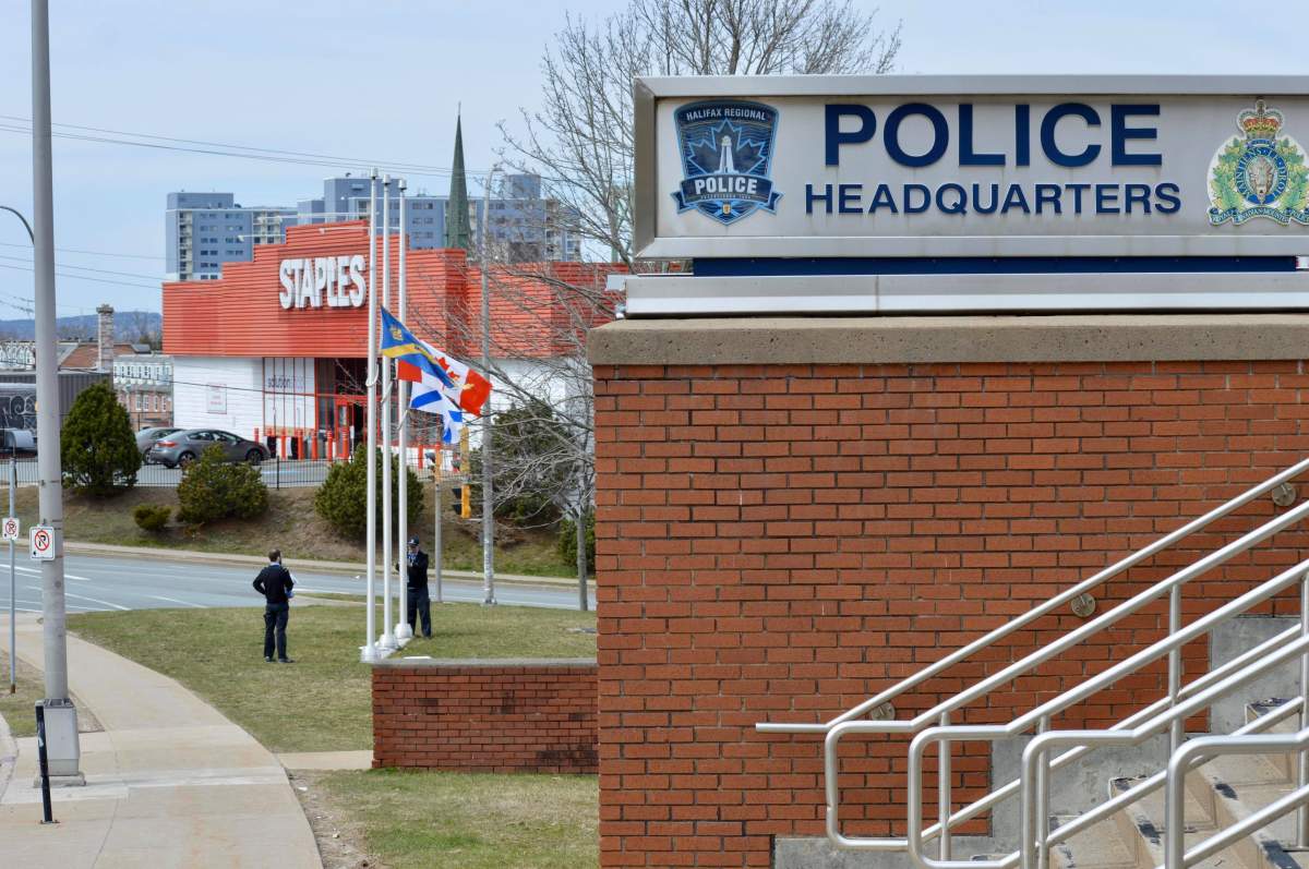Staff move flags to the half-mast at  Halifax Regional Police's Headquarters on Gottingen Street in Halifax, N.S., on April 20, 2020. 