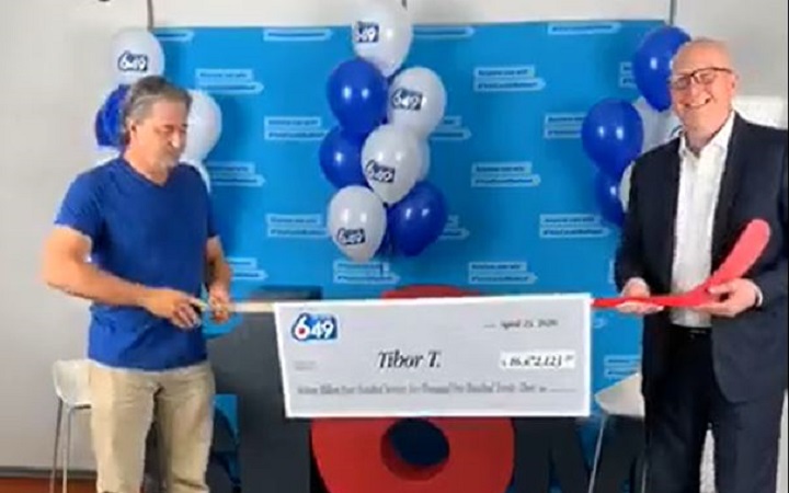 B.C. man wins $16M Lotto 6/49 jackpot, officials use hockey stick to give him the cheque - image