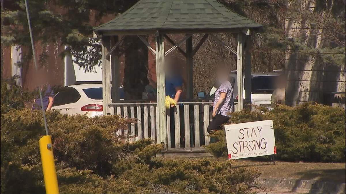 People wear personal protective gear outside the Pinecrest Nursing Home in Bobcaygeon, Ont., on April 1, 2020.