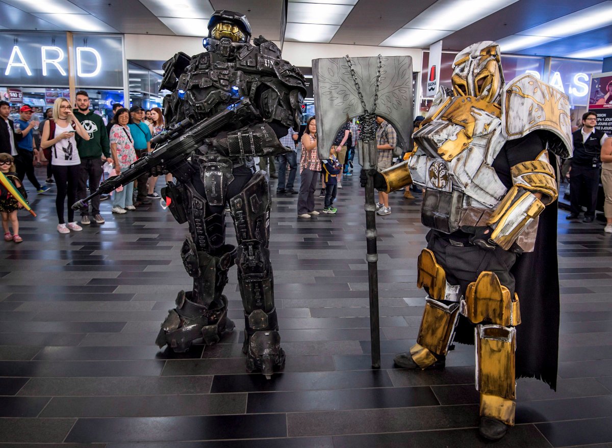 Frank Roy, left, dressed as Heavy Master Chief, of Halo fame, and Frederick Villeneuve, right, as Lord Saladin of Destiny pose outside the Montreal Comic-Con on Saturday, July 8, 2017.