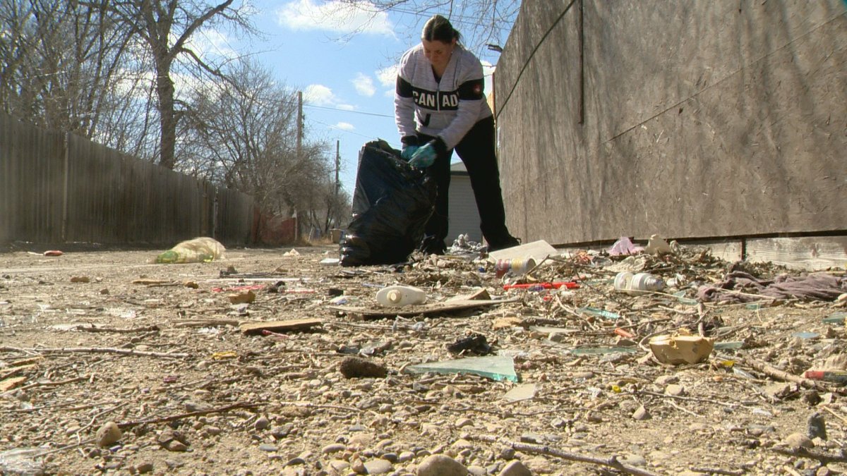 Maria Spottek cleans up an alley in North Central Regina on April 19, 2020.