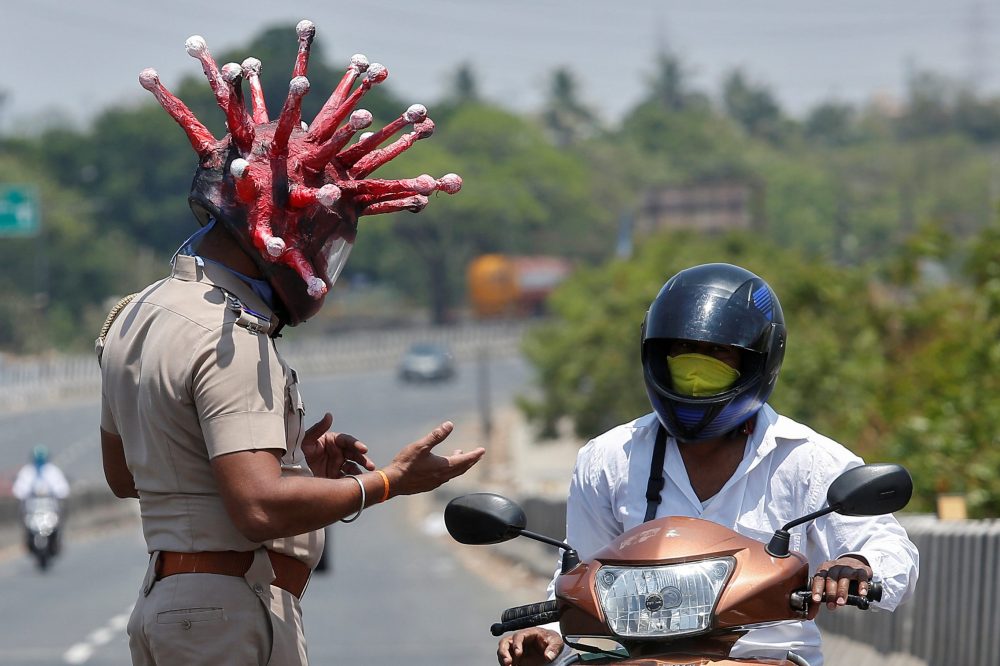 Rajesh Babu, a police officer, wearing a helmet depicting coronavirus, asks a commuter to stay at home during a 21-day nationwide lockdown to limit the spreading of coronavirus disease in Chennai, India, March 28, 2020.