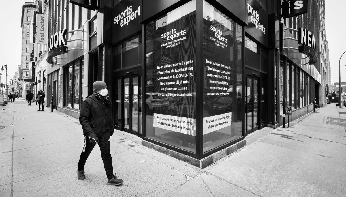 A man walks past a closed Sports Experts store on Ste-Catherine Street in downtown Montreal, Monday March 23, 2020, after all non-non-essential businesses were ordered shuttered. Phil Carpenter/Global News