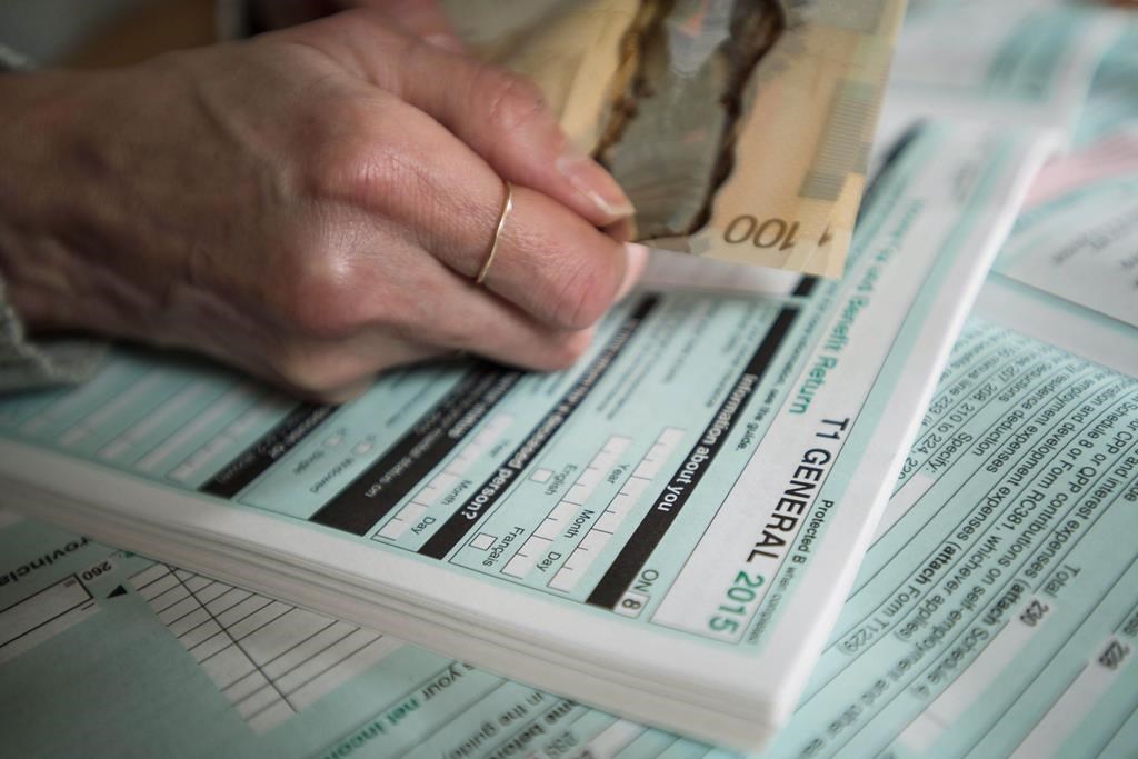 Tax forms and Canadian currency are shown together in this photo illustration.