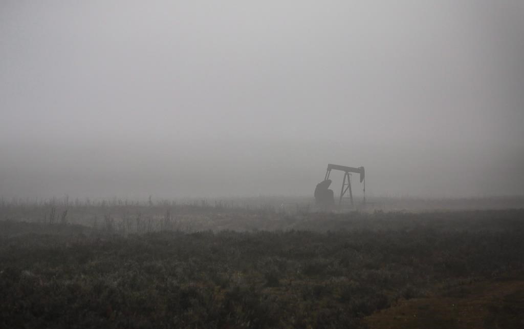 A pumpjack works at a well head on an oil and gas installation on a foggy day near Cremona, Alta., Saturday, Oct. 29, 2016.