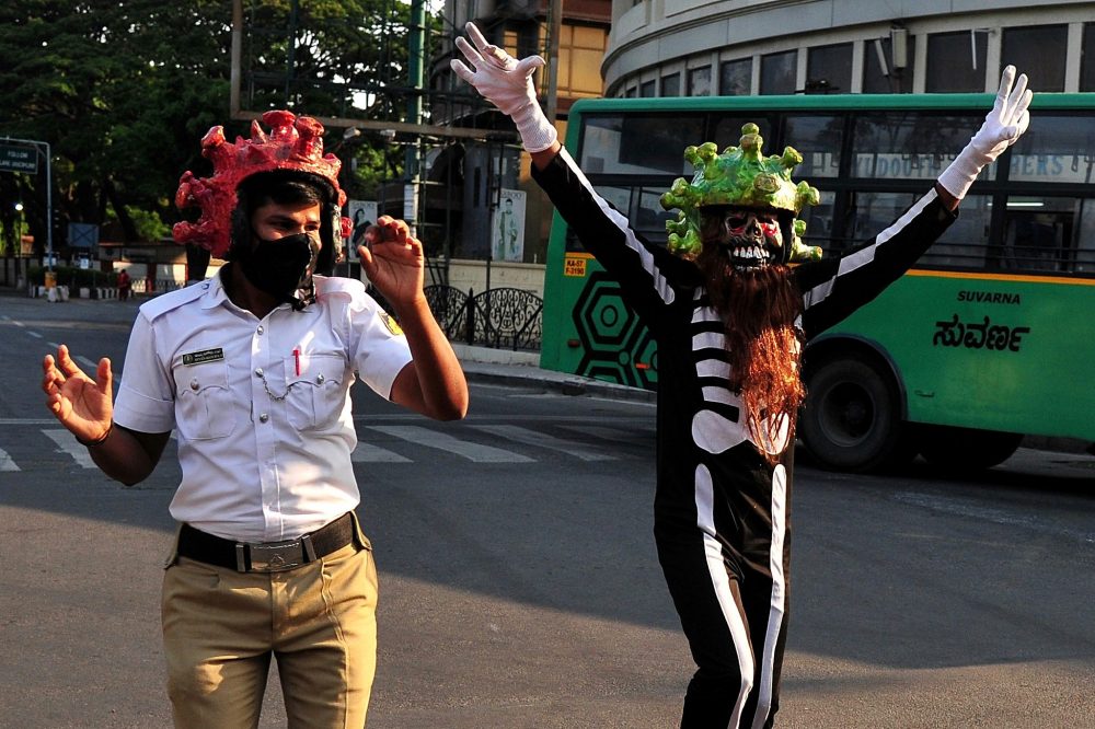 An Indian traffic policeman wears a coronavirus helmet look-alike during a demon act to create awareness among people and urge them to stay at home during the ninth day of a nationwide lockdown against the spread of the novel coronavirus disease in Bangalore, India, April 2, 2020.