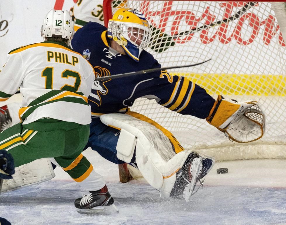 University of Alberta Golden Bears' Luke Philip slides the puck past University of Lethbridge Pronhorns goaltender Garret Hughson during U CUP hockey action Thursday, March 14, 2019, in Lethbridge, Alberta. The University of Lethbridge has shut down its men's and women's hockey teams citing three straight years of cuts to its operating grant. THE CANADIAN PRESS/David Rossiter.