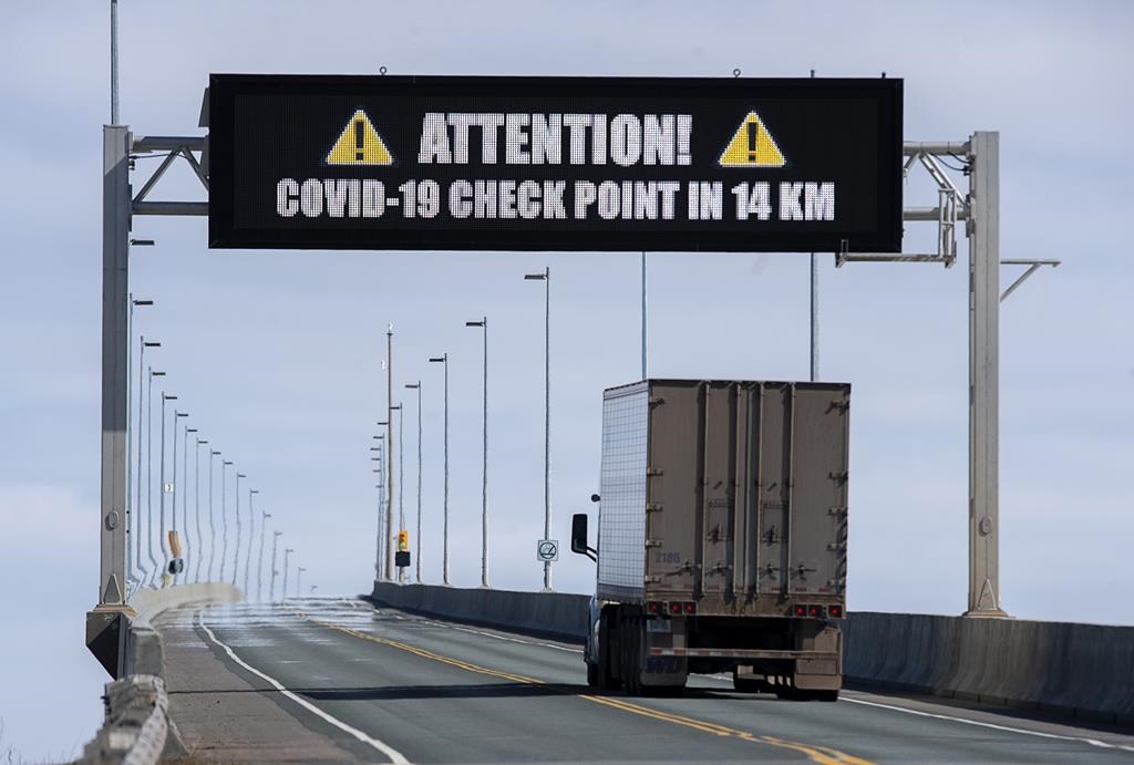 A sign indicates that provincial health department workers will stop traffic that has crossed the Confederation Bridge in Cape Jourimain, N.B. on Sunday, March 22, 2020.
