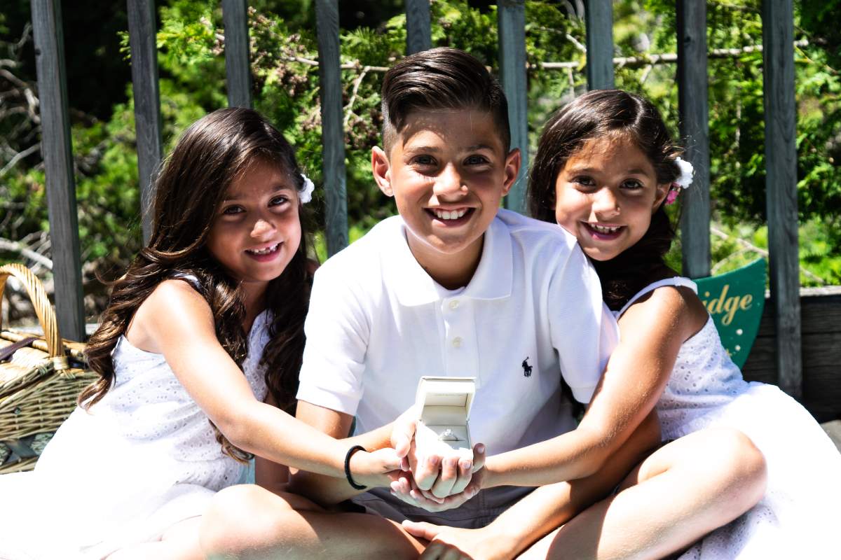 Three of Erin and Corey’s children holding Erin’s engagement ring from Corey Cooper. Photo by Brendan Pyne