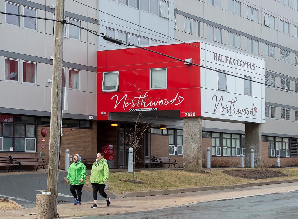 Two women walk past Northwood Manor in Halifax on Monday, April 13, 2020.