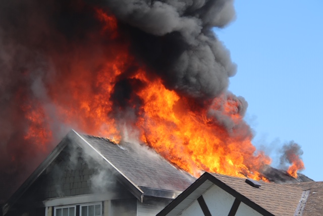 Black smoke and flames rise from a home under construction in Surrey on April 12, 2020.
