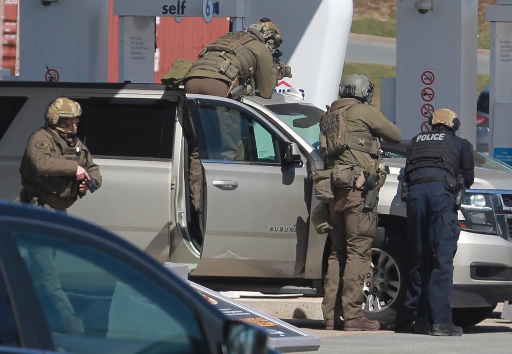 RCMP officers prepare to take a person into custody at a gas station in Enfield, N.S. on Sunday April 19, 2020.