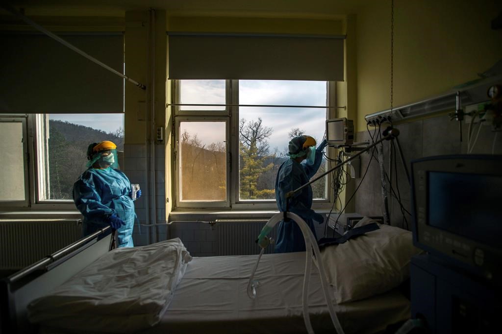 FILE - In this March 24, 2020, file photo, medical staff members check a ventilator in protective suits at the care unit for the new COVID-19 infected patients inside the Koranyi National Institute of Pulmonology in Budapest.
