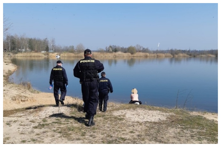 Police approach a sunbather near a pond in the Czech Republic on March 27, 2020.