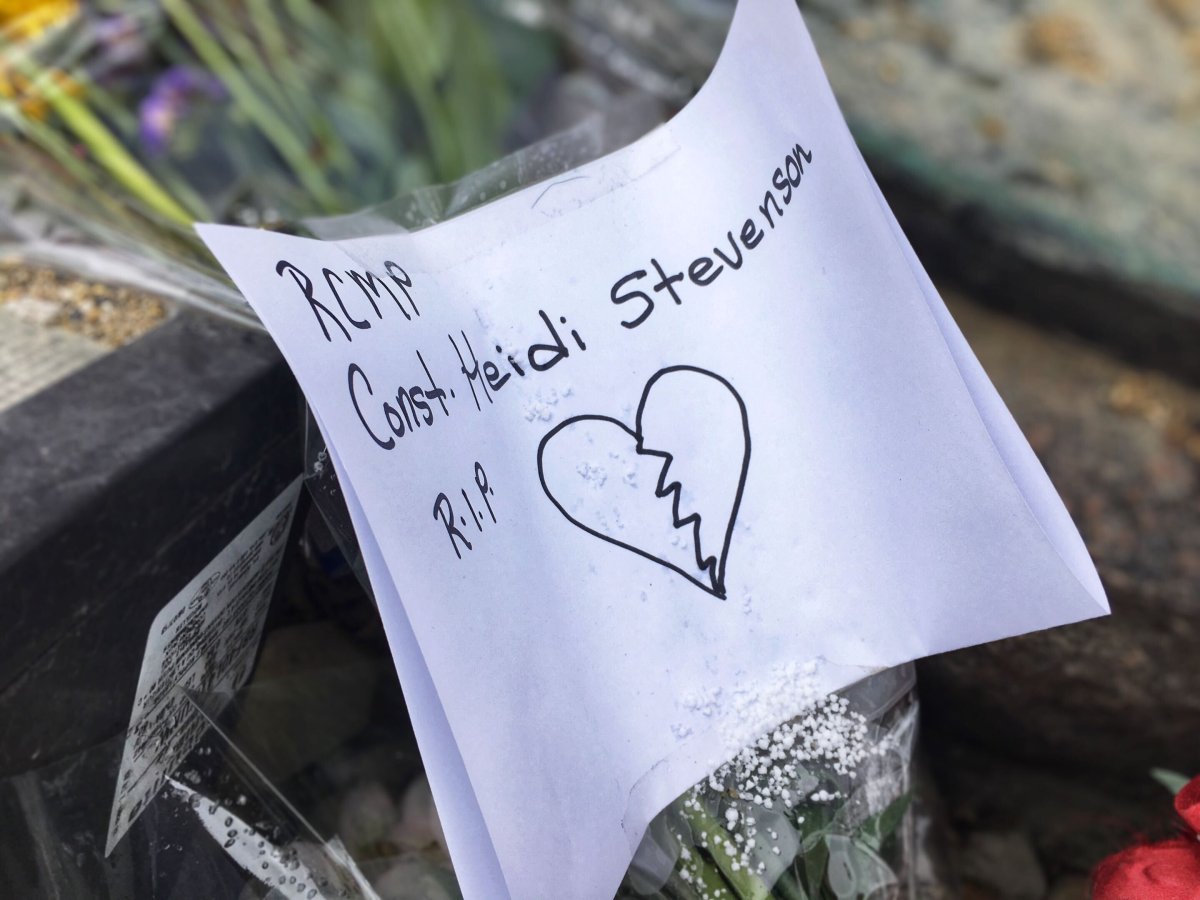 A handwritten card is placed by a monument outside RCMP D Division in Winnipeg.