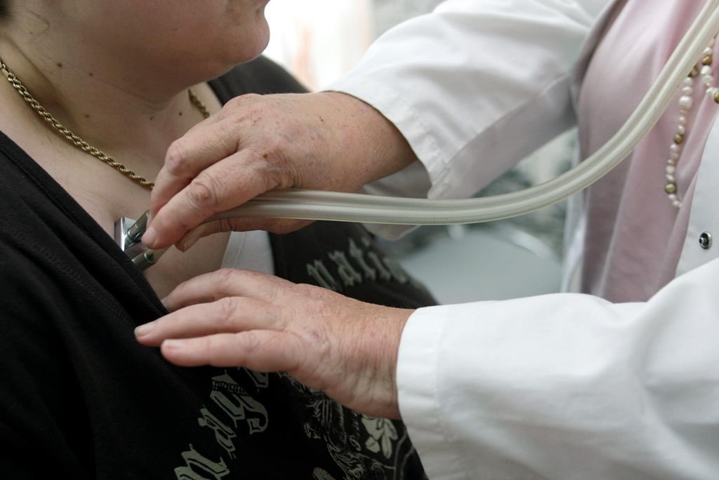 A doctor examines a patient with a stethoscope in her doctor's office in Stuttgart, Germany, Monday, April 28, 2008.