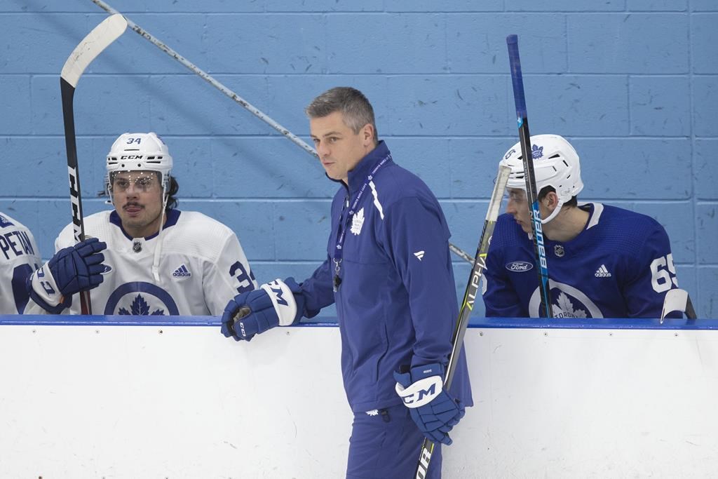 Toronto Maple Leafs coach Sheldon Keefe, centre, stands by centre Auston Matthews (left) as he runs a practic in Toronto on Monday, November 25, 2019.