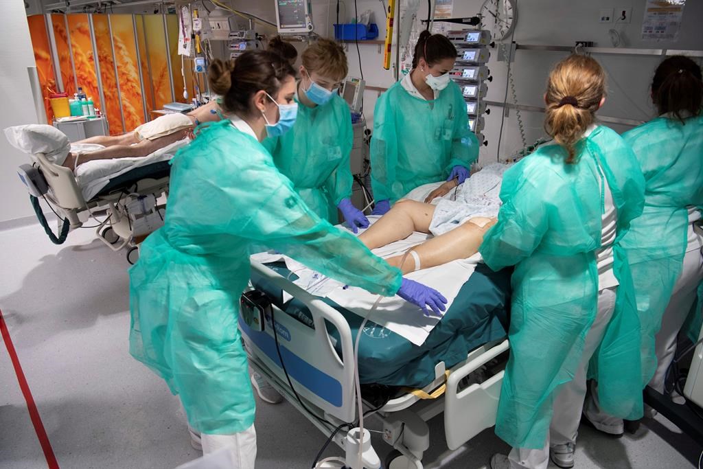 FILE - Medical workers treat a patient with COVID-19 in the intensive care unit at the University Hospital (CHUV) during the state of emergency of the coronavirus disease (COVID-19) outbreak, in Lausanne, Switzerland, Friday, April 3, 2020.