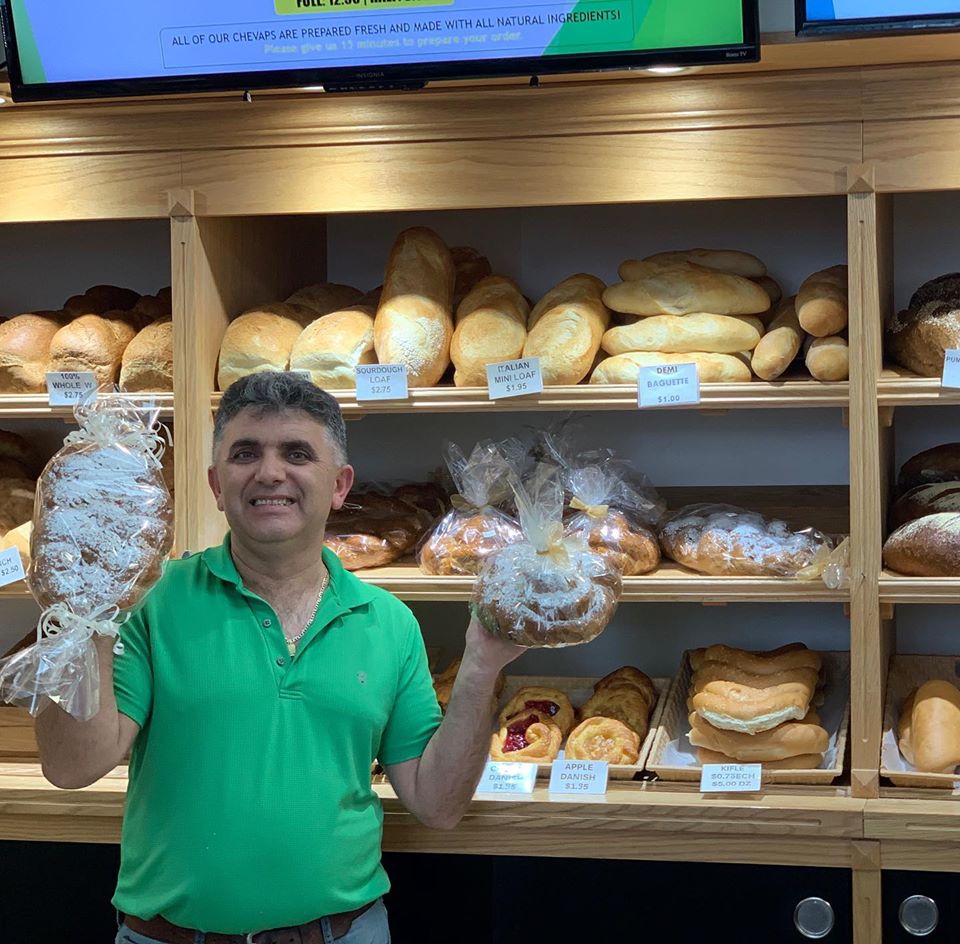 Owner of European Bakery in Calgary Shaqir Duraj holding some of his bakery's loaves of bread.
