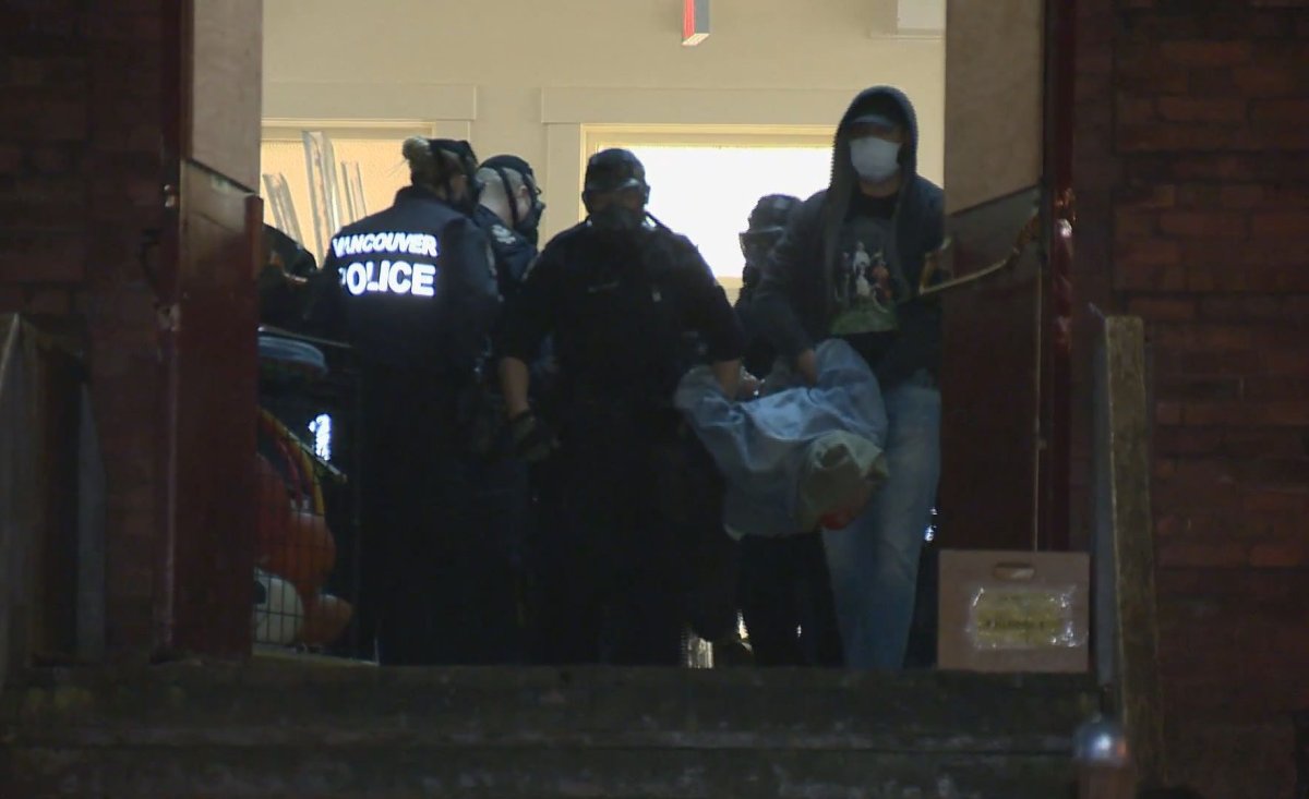 An activist is taken out of Lord Strathcona Elementary School by Vancouver police on April 19, 2020.