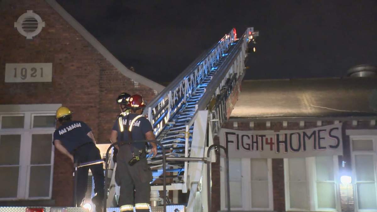 Vancouver fire crews bring a ladder truck to Lord Strathcona Elementary School to bring protesters down from the roof on April 19, 2020.