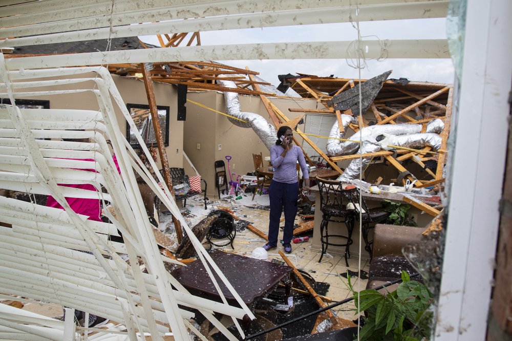 Rolanda Robinson calls family and friends from her brother’s damaged home in Monroe, La. after a tornado ripped through the town on Sunday, April 12, 2020. (Nicolas Galindo/The News-Star via AP)