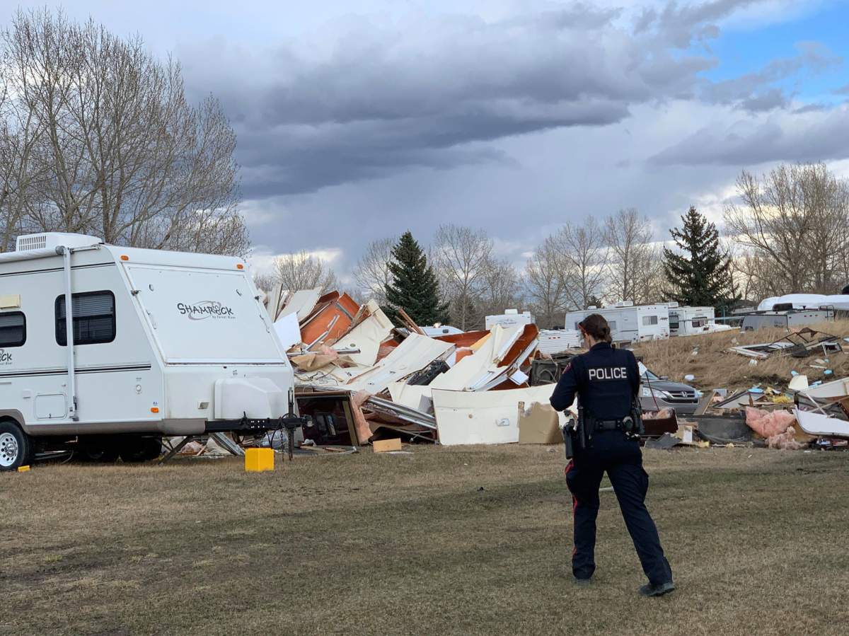 A Calgary police officer walks near the scene of an RV explosion that killed one person in Calgary.
