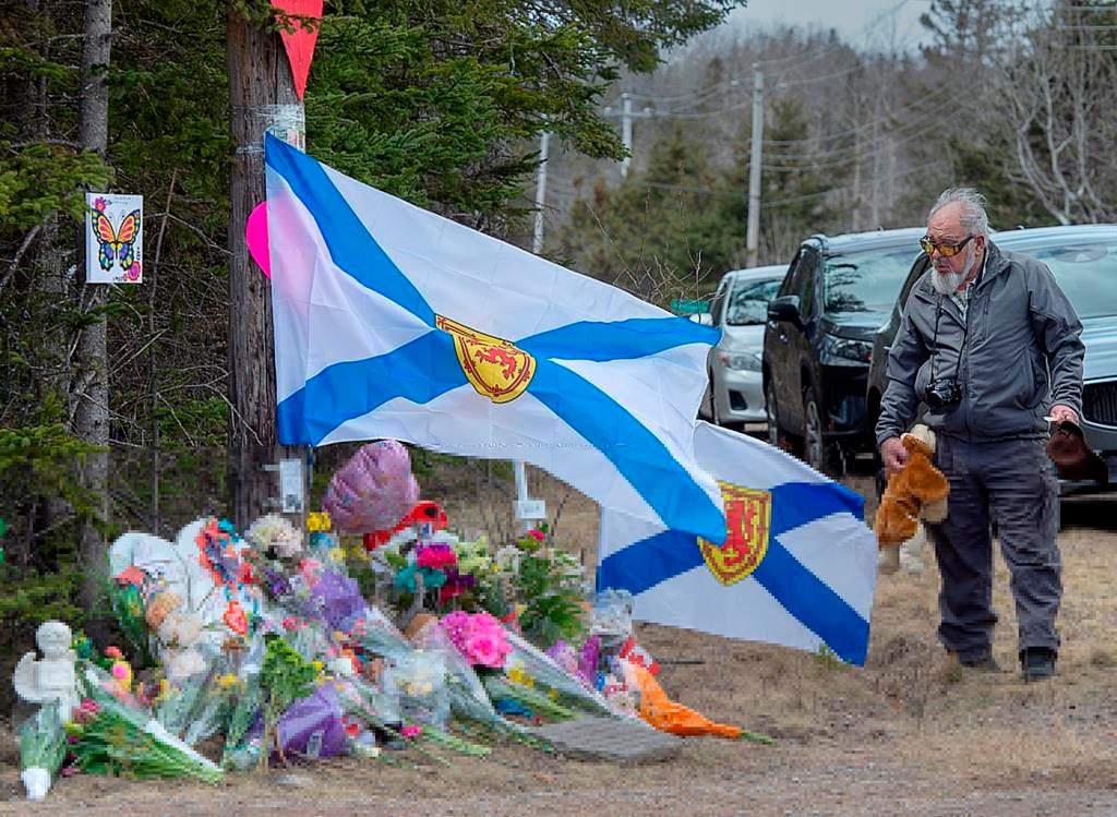 A man pays his respects at a roadside memorial in Portapique, N.S., on Thursday.