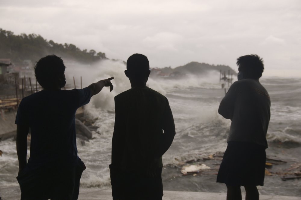 Men watch as strong waves caused by typhoon Vongfong batter the coastline of Catbalogan city, Western Samar province, eastern Philippines, Thursday, May, 14, 2020. A strong typhoon slammed into the eastern Philippines on Thursday after authorities evacuated tens of thousands of people while trying to avoid the virus risks of overcrowding emergency shelters. 