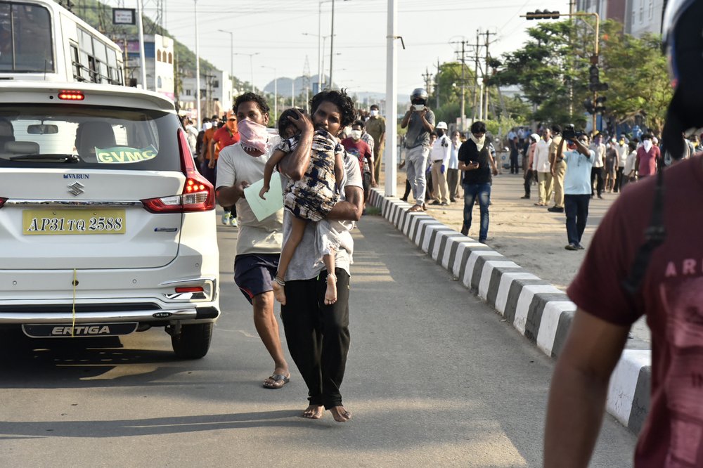 A man runs carrying a child affected by a chemical gas leak in Vishakhapatnam, India, Thursday, May 7, 2020. Chemical gas leaked from an industrial plant in southern India early Thursday, leaving people struggling to breathe and collapsing in the streets as they tried to flee. Administrator Vinay Chand said several people fainted on the road and were rushed to a hospital. 