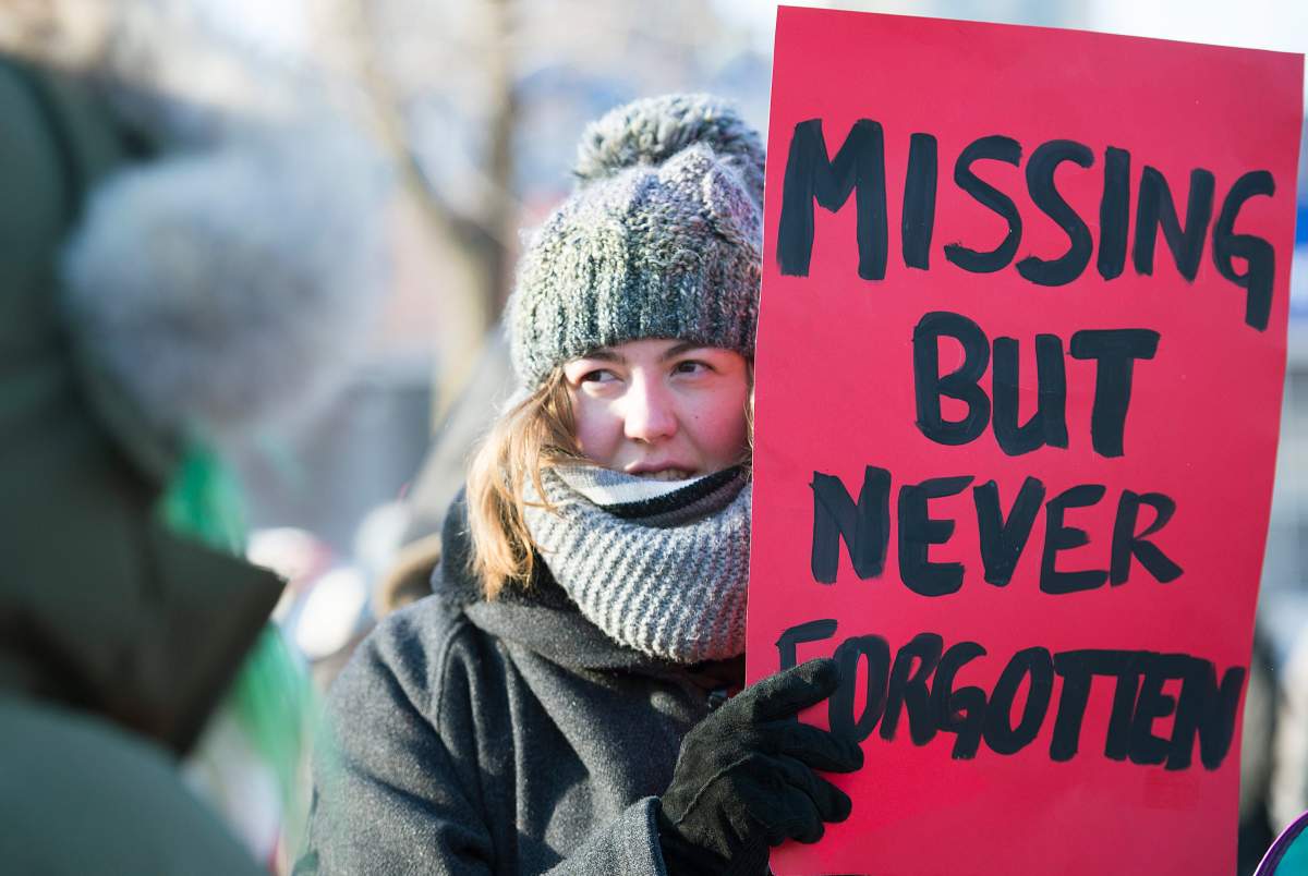 A woman holds up a sign during the seventh annual memorial march to raise awareness for the thousands of missing and murdered Indigenous women in Montreal, Sunday, Feb. 14, 2016.