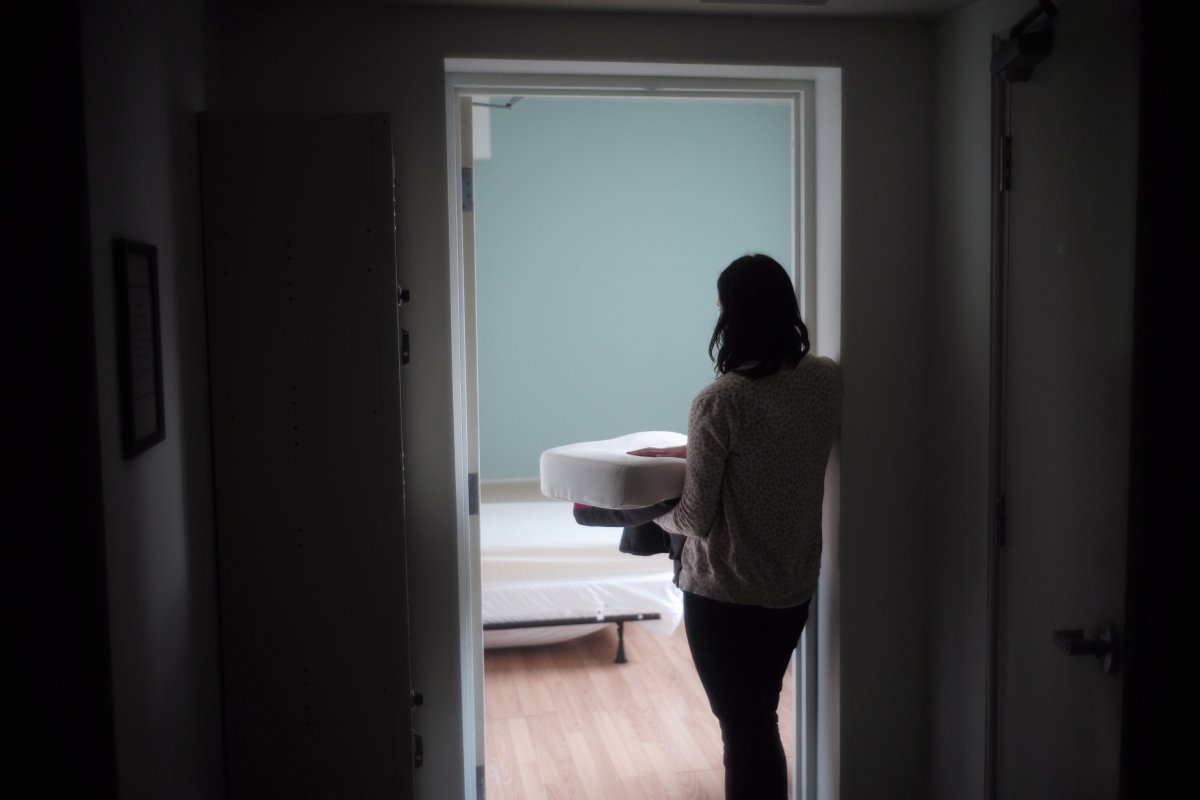 A staff member carries bedding in one of the suites at Toronto's Interval House, an emergency shelter for women in abusive situations, on Monday, Feb. 6, 2017.