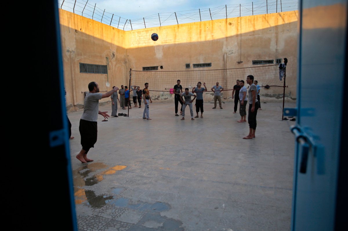 In this April 3, 2018 file photo, prisoners play volleyball, in a Kurdish-run prison housing former members of the Islamic State group, in Qamishli, north Syria.