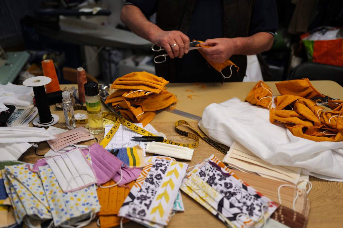Tailor Yalcine of Boulard Retouche prepares face protective masks in cotton sewn in his shop at the Daguerre district in Paris, Sunday, May 3, 2020 as a nationwide confinement continue to counter the COVID-19. 