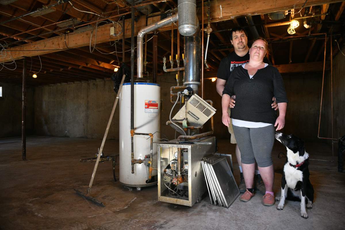 Homeowners Cora and Alec Dion pose in the basement of their home in Fort McMurray, Alta., on May 8, 2020. The Dions had about five feet of water in their basement as a result of recent flooding in downtown Fort McMurray. This marked the second time the couple faced evacuation from their home since the Horse River wild fire of May 3, 2016. THE CANADIAN PRESS/Greg Halinda
