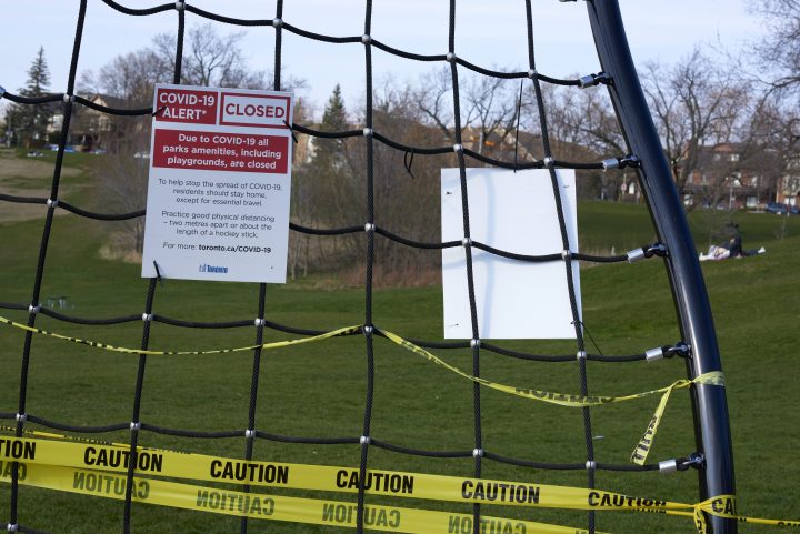 COVID-19 Alert signs and caution tape hang from an outdoor calisthenics gym at Riverdale Park East in Toronto on April 28, 2020. 