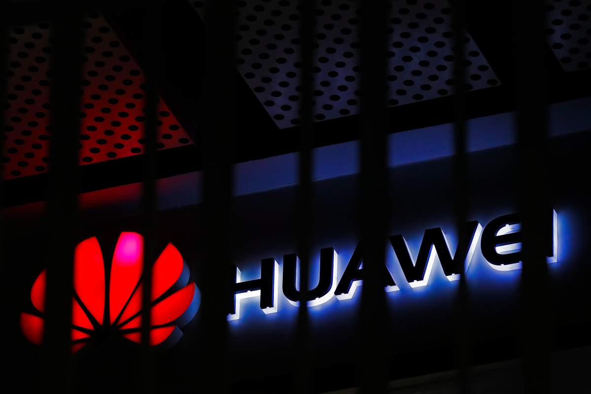 FILE - In this March 8, 2019, file photo, A logo of Huawei retail shop is seen through a handrail inside a commercial office building in Beijing.