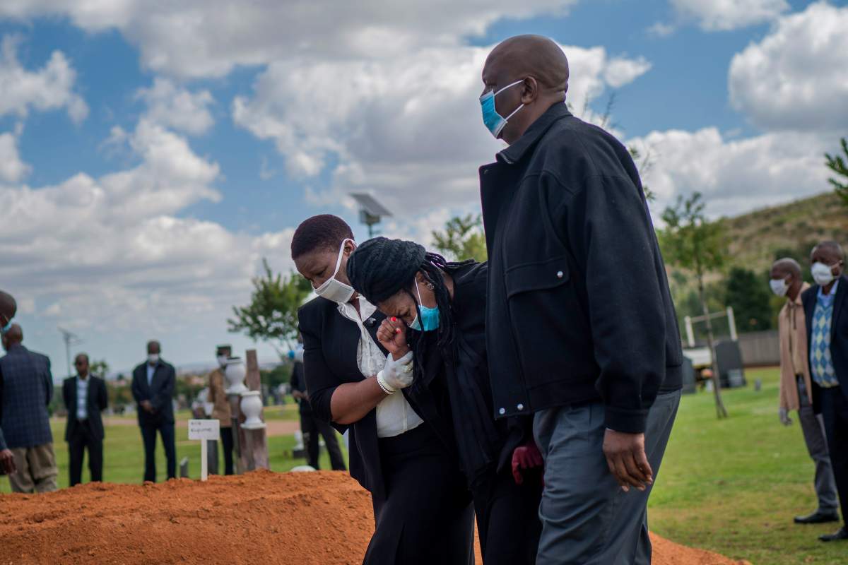 FILE - In this Sunday, April 12, 2020 file photo, relatives grieve for Benedict Somi Vilakasi, a Soweto coffee shop manager who died of a COVID-19 infection in a Johannesburg hospital, at his burial ceremony at the Nasrec Memorial Park outside Johannesburg, South Africa Thursday, April 16, 2020.