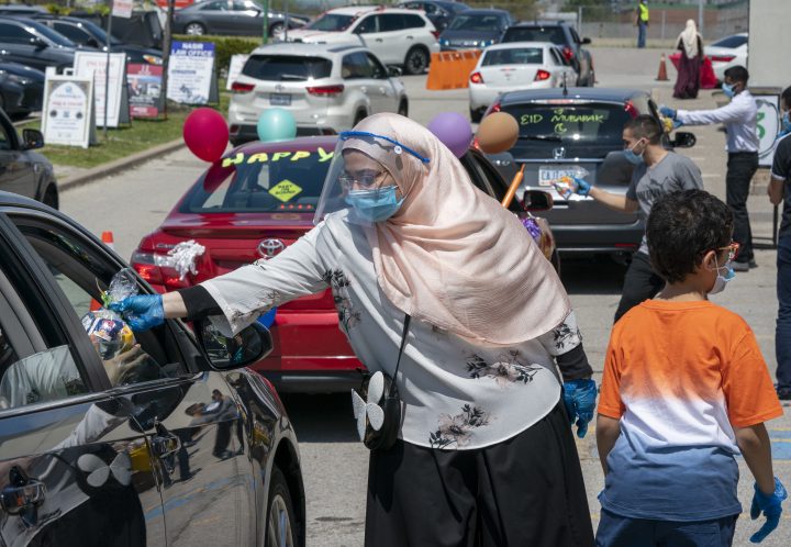 Islamic Society of North America Mosque community members hand out candy to children in a drive through Eid celebration on Sunday, May 24, 2020. The celebration lasted hours with thousands participating.