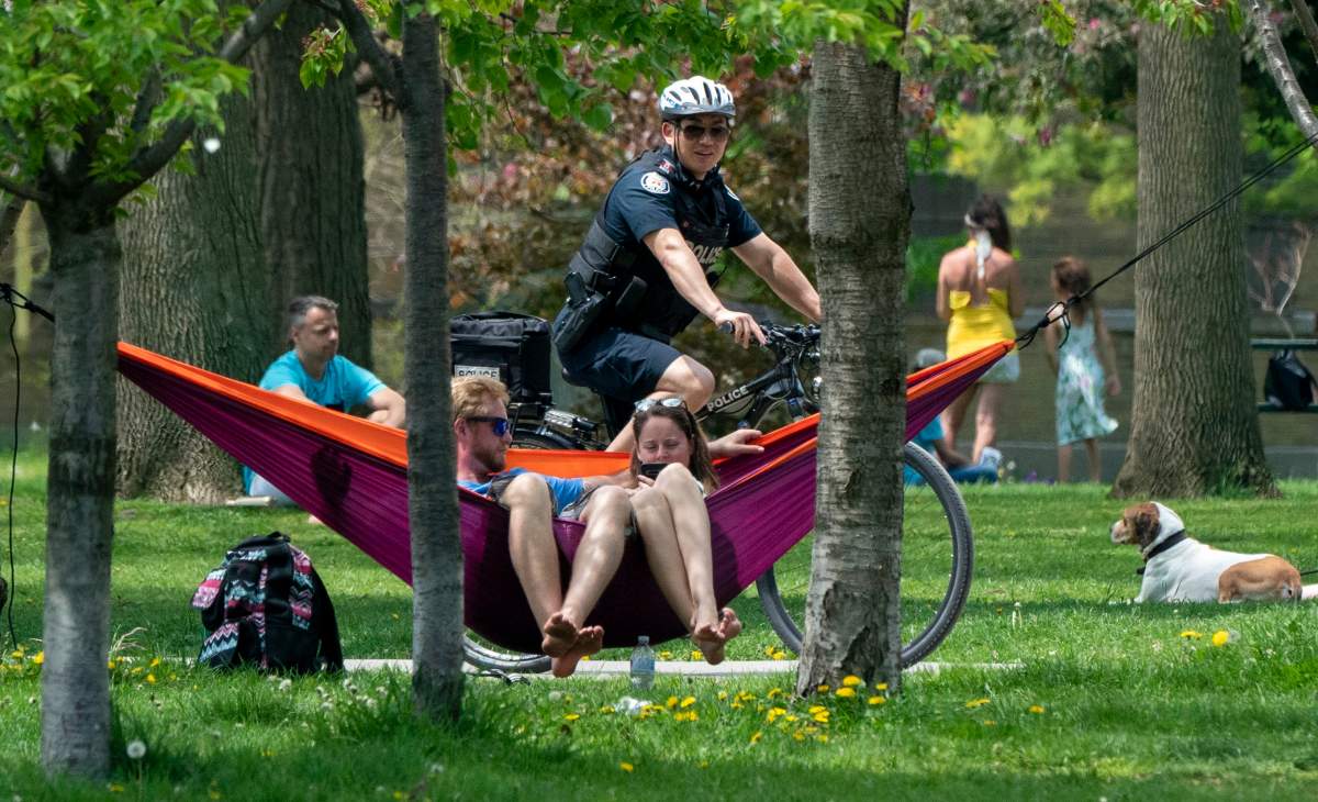 A bicycle police officer patrols Trinity Bellwoods Park in Toronto on Sunday, May 24, 2020. Warm weather and a reduction in COVID-19 restrictions has many looking to the outdoors for relief. THE CANADIAN PRESS/Frank Gunn.
